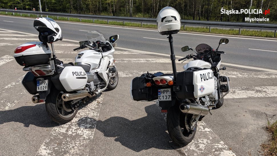 dwa policyjne motocykle zaparkowane przy drodze