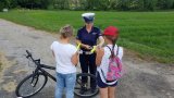 policjantka wręcza odblaski rowerzystce i jej córce