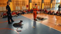policjant i strażak ratownik opowiadają dzieciom o pierwszej pomocy