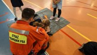 dzieci ćwiczą udzielanie pierwszej pomocy pod okiem strażaka ratownika