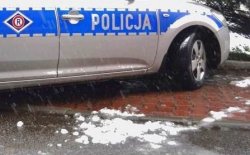 policyjny radiowóz i zaśnieżona nawierzchnia drogi
