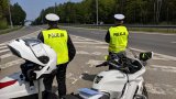 policjanci ruchu drogowego przy motocyklach obserwują ruch pojazdów