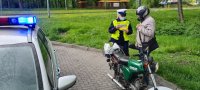 policjantka wręcza motorowerzyście odblask i kamizelkę odblaskową