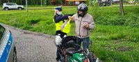policjantka pomaga motorowerzyście założyć kamizelkę odblaskową